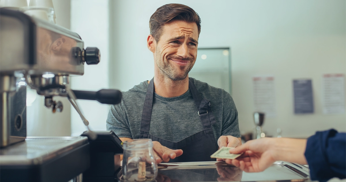 A barista preparing espresso drinks at a coffee stand