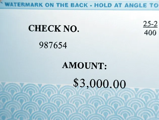 Class action settlement check showing security printing and a watermark notice along the top edge