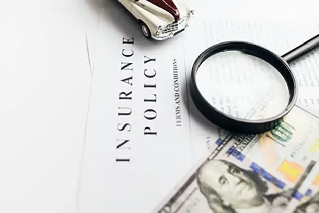 An auto insurance policy under a magnifying glass, illustrating the GEICO C.L.U.E. report settlement