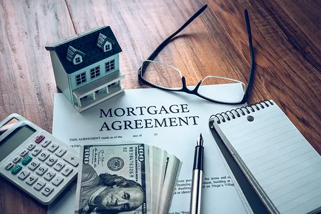 Model house on mortgage documents representing the Dovenmuehle pay-to-pay fee settlement