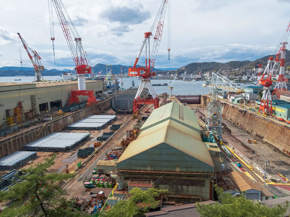 Cranes over shipyard dry docks — naval architects and marine engineers reached $8.175 million in no-poach settlements