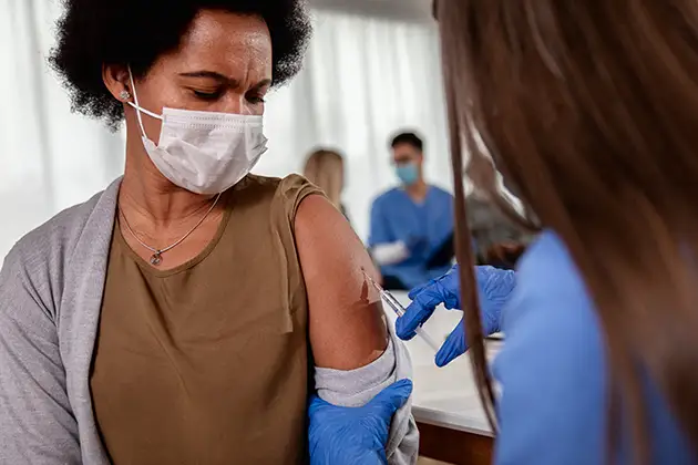 Health worker in gloves giving a vaccine injection to a patient