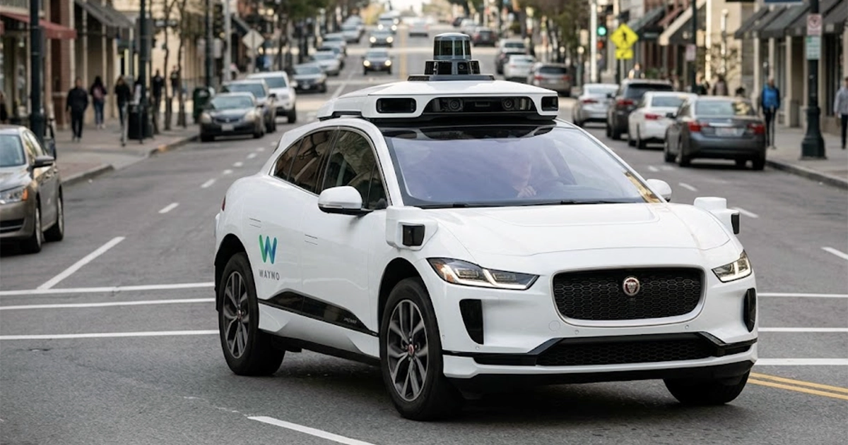 A driverless Waymo Jaguar I-PACE robotaxi on a city street — the vehicle type covered by Waymo's NHTSA software recalls